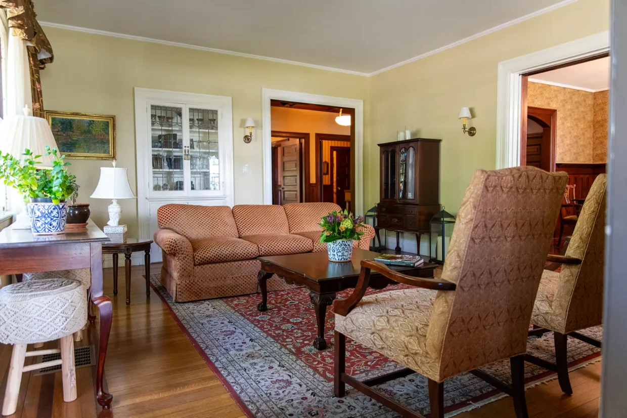 Cozy common area featuring a patterned sofa, armchairs, and decorative elements, inviting relaxation and social interaction.