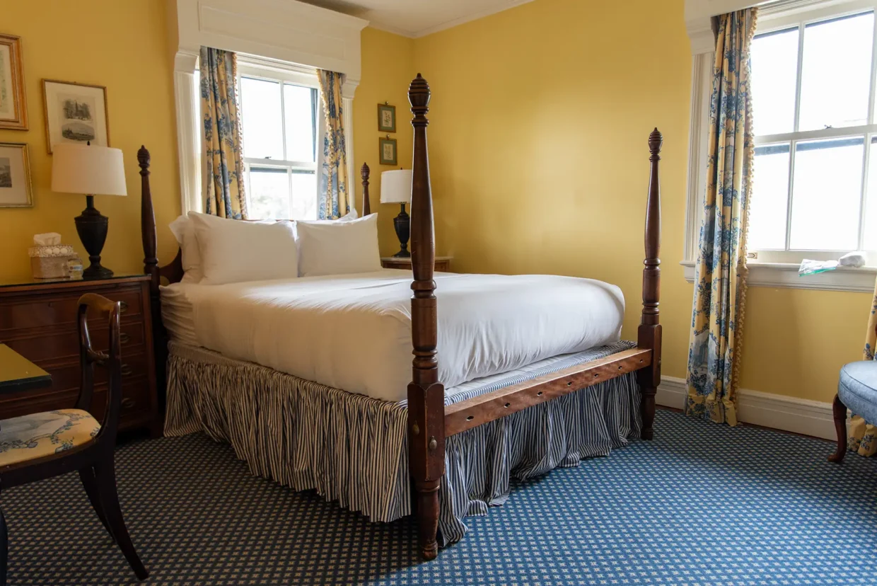 Cozy Murray Room featuring a four-poster bed, yellow walls, and elegant decor for a relaxing stay.