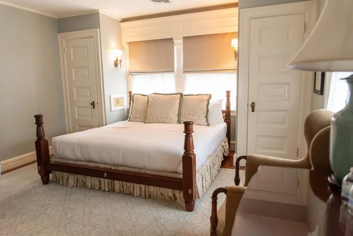 Cozy Touro Room featuring a queen bed, elegant decor, and natural light from large windows.